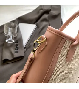 Detail of premium golden hardware and beige woven fabric on a luxury tote bag