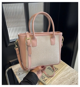 Detail view of woven pink patchwork tote bag with gold hardware and top handle