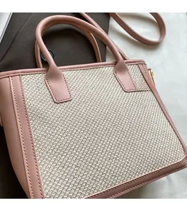 Detail showing the pink faux leather trim and beige woven texture of this tote bag