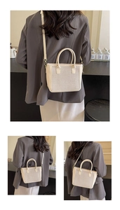Detail showing hand-woven beige tote bag with smooth faux leather trim and strap