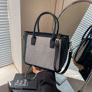 Minimalist woven tote bag with black leather trim and golden hardware for women