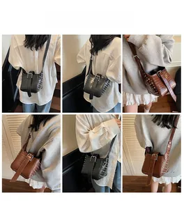 Crocodile pattern bucket bag with silver studs worn by a model in black and brown