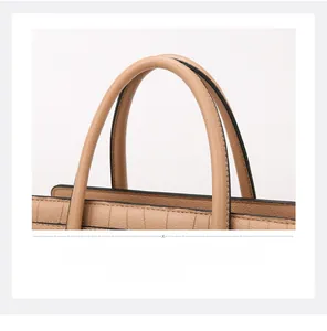 Detail of khaki faux leather handbag featuring textured stone pattern and round handles