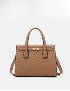 Detail of brown crocodile pattern handbag featuring a golden twist-lock and top handle