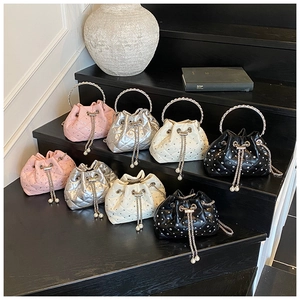 Detail of multi-color quilted bucket bags with crystal chains and metallic handles
