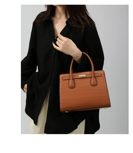 Detail of dark brown stone pattern handbag with gold hardware and classic twist lock