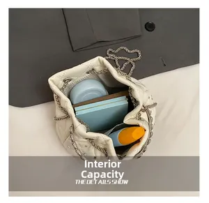 Internal capacity of quilted bucket bag with chain strap showing storage space and lining