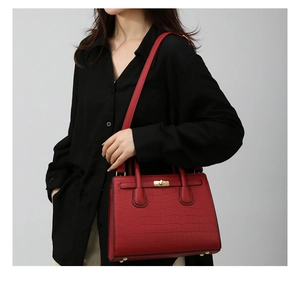 Detail of red stone pattern handbag with gold twist lock and sturdy protective feet