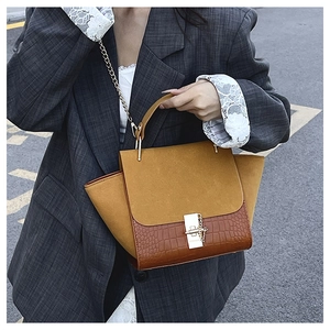 Close-up of wing bag featuring frosted ginger suede and dark brown croc-texture leather
