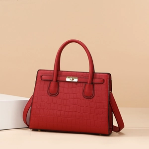 Detailed view of red stone pattern texture and gold buckle on stylish tote bag