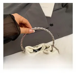 Detail of white quilted bucket bag with silver rhinestones and metal ring handle