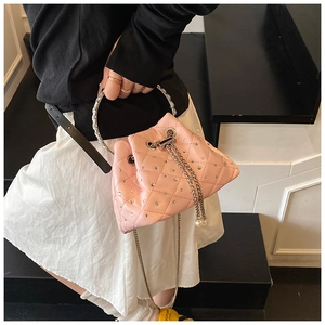 Detail of pink quilted bucket bag with rhinestones, silver ring handle and pearl chain