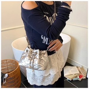 Detail of silver quilted bucket bag with shimmering rhinestones and pearl drawstring charms