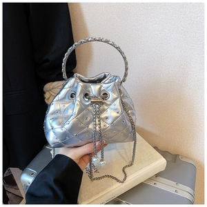 Detail view of silver quilted bucket bag with rhinestones and metal ring handle