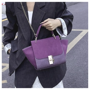 Detail of vintage purple wing bag featuring matte finish and crocodile texture contrast