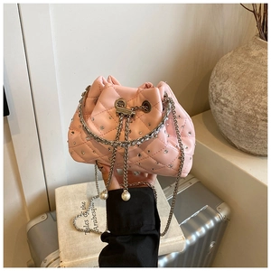 Detailed shot of pink quilted bucket bag with sparkly rhinestones and pearl drawstrings