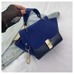 Detail of navy blue crocodile embossed leather and gold clasp on the chain handbag