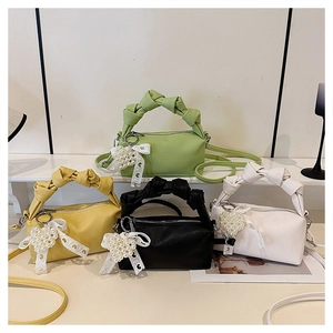 Detail of colorful cloud bags with woven handles, metal zippers and pearl heart charms