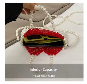 Internal capacity of red and white beaded heart bag holding sunglasses and phone