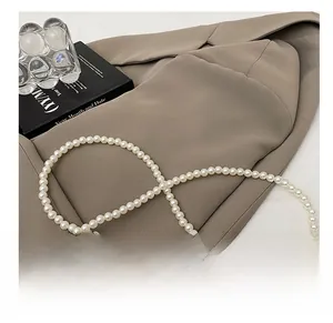 Detail of elegant white faux pearl strap with smooth finish on neutral background
