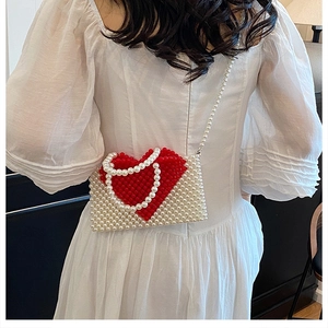 Handmade beaded heart-shaped shoulder bag featuring red and cream beads with long strap