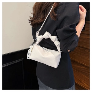 Detail of white lychee grain handbag with knotted handle and polka dot lace ribbon