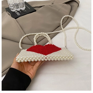 Detail of handmade pearl handbag featuring a unique red lip design and pearl chain strap