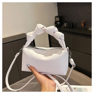 Detail of white lychee pattern leather handbag with oversized knot handle and silver zipper
