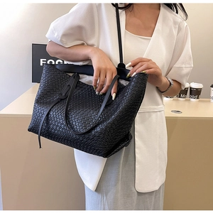 Close-up of black woven tote bag texture with model in casual outfit in studio