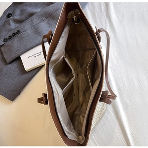 Interior view showing the large capacity main compartment and pockets of the woven tote bag