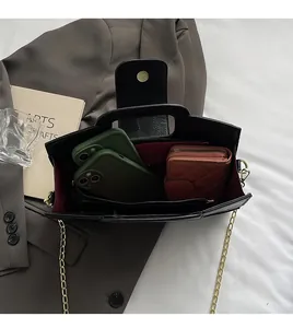 Top view of leather handbag interior with red lining, gold chain, and spacious compartments
