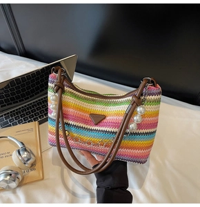 Close-up of colorful striped woven beach bag with pearl charm and fashion leather tag