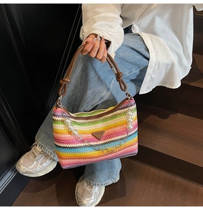 Detail of colorful rainbow striped woven tote bag with pearl chain and leather handle