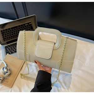 Detail of cream white leather bag with geometric stitching and gold chain strap