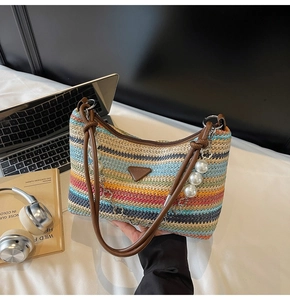 Detail of colorful striped woven beach bag with pearl chain and leather shoulder strap