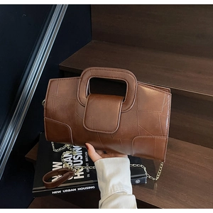 Detailed view of vintage brown patchwork leather handbag with metal chain strap