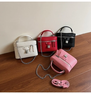 Detail view of four textured leather box bags in white, red, black, and pink colors