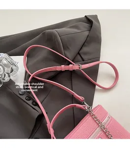 Detail of pink lychee leather handbag with adjustable strap and silver metal chain
