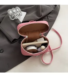 Pink lychee leather mini crossbody bag showing internal space for phone and cosmetics