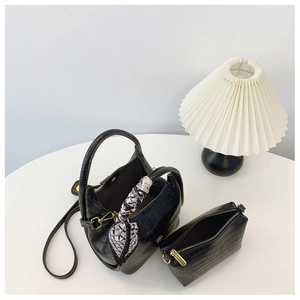 Detail of black crocodile texture bucket bag with silk scarf and matching pouch