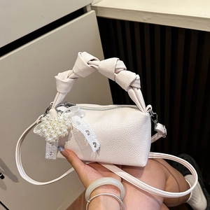 Chic beige lychee leather barrel bag with knotted handle and pearl heart charm