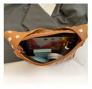 Macro detail of the spacious interior of the studded brown leather underarm bag
