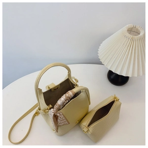 Close-up of cream crocodile pattern bucket bag and matching pouch with silk scarf