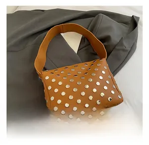 Close-up of brown litchi pattern leather shoulder bag with silver metal rivet studs