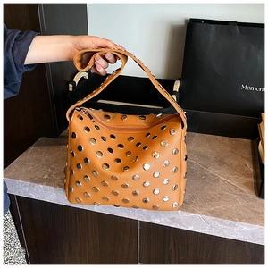 Detailed shot of brown litchi grain leather shoulder bag with silver metal studs