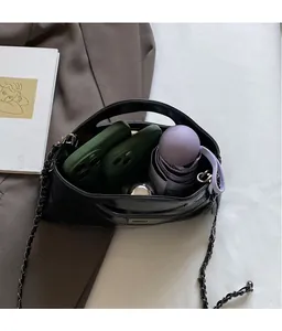 Top view of spacious interior of black chain shoulder bag holding a phone and umbrella