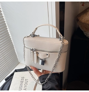 Close-up of cream box bag showing lychee grain leather and silver lock detail