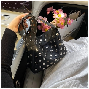 Close-up of black rivet shoulder bag with silver studs and lychee grain leather finish