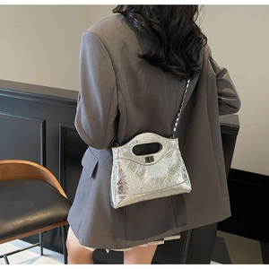 Detail of silver quilted chain bag featuring metallic finish and glossy leather texture