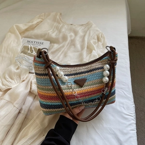 Rainbow striped woven tote bag with brown leather handles and pearl charm accessory